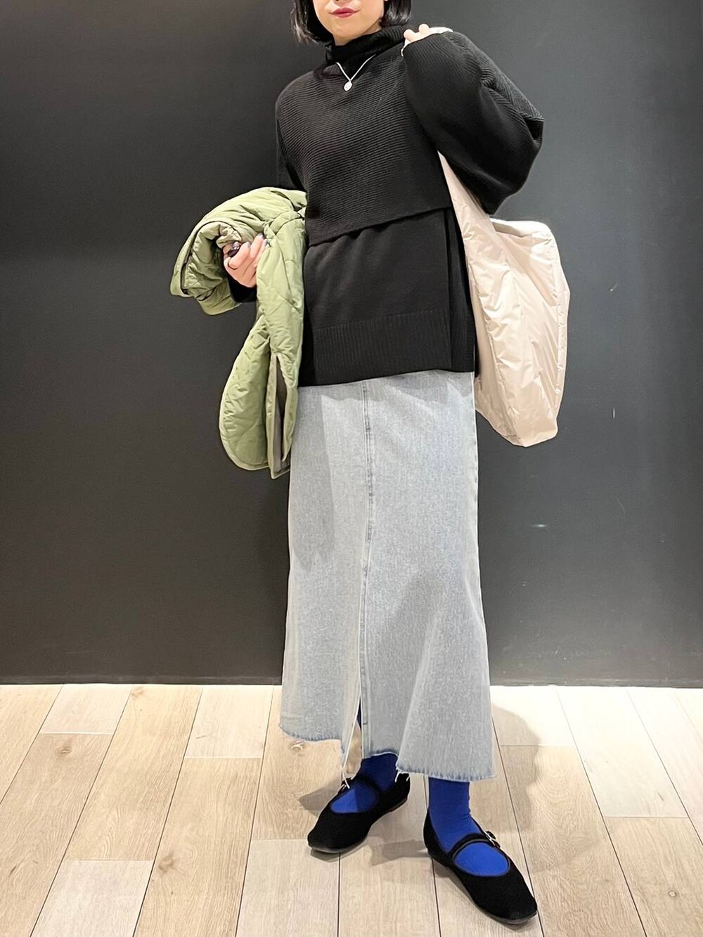 ブラック系のニット/セーター、ホワイト系のショルダーバッグ、ブラック系のバレエシューズを着用したレディースの冬コーディネートの4枚目の写真