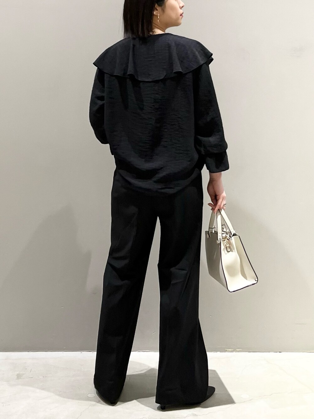 ブラック系のシャツ/ブラウス、ブラック系のバッグ、ブラック系のパンツを着用したレディースの春コーディネートの5枚目の写真