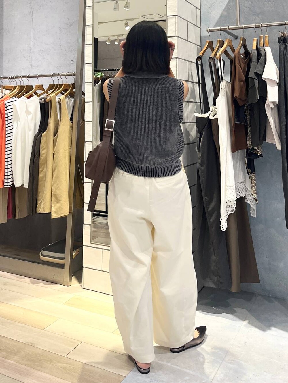 ブラウン系のショルダーバッグ、ホワイト系のタンクトップ、シルバー系のキーホルダーを着用したレディースの夏コーディネートの6枚目の写真