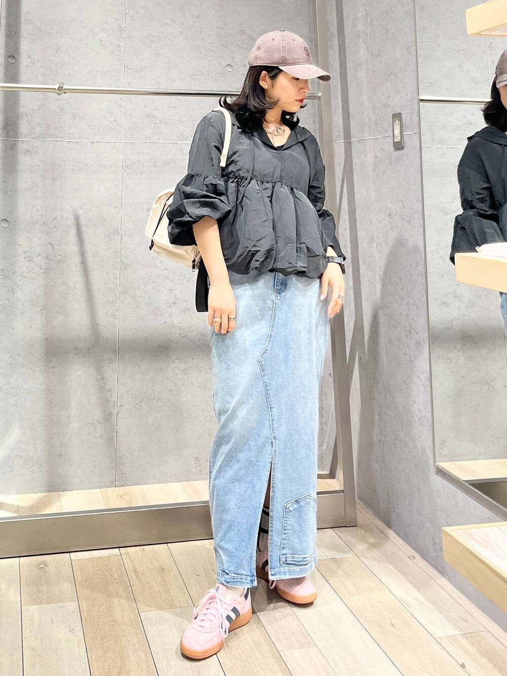 ホワイト系のショルダーバッグ、ブルー系のデニムスカート、ブラウン系のキャップを着用したレディースの冬コーディネートの6枚目の写真