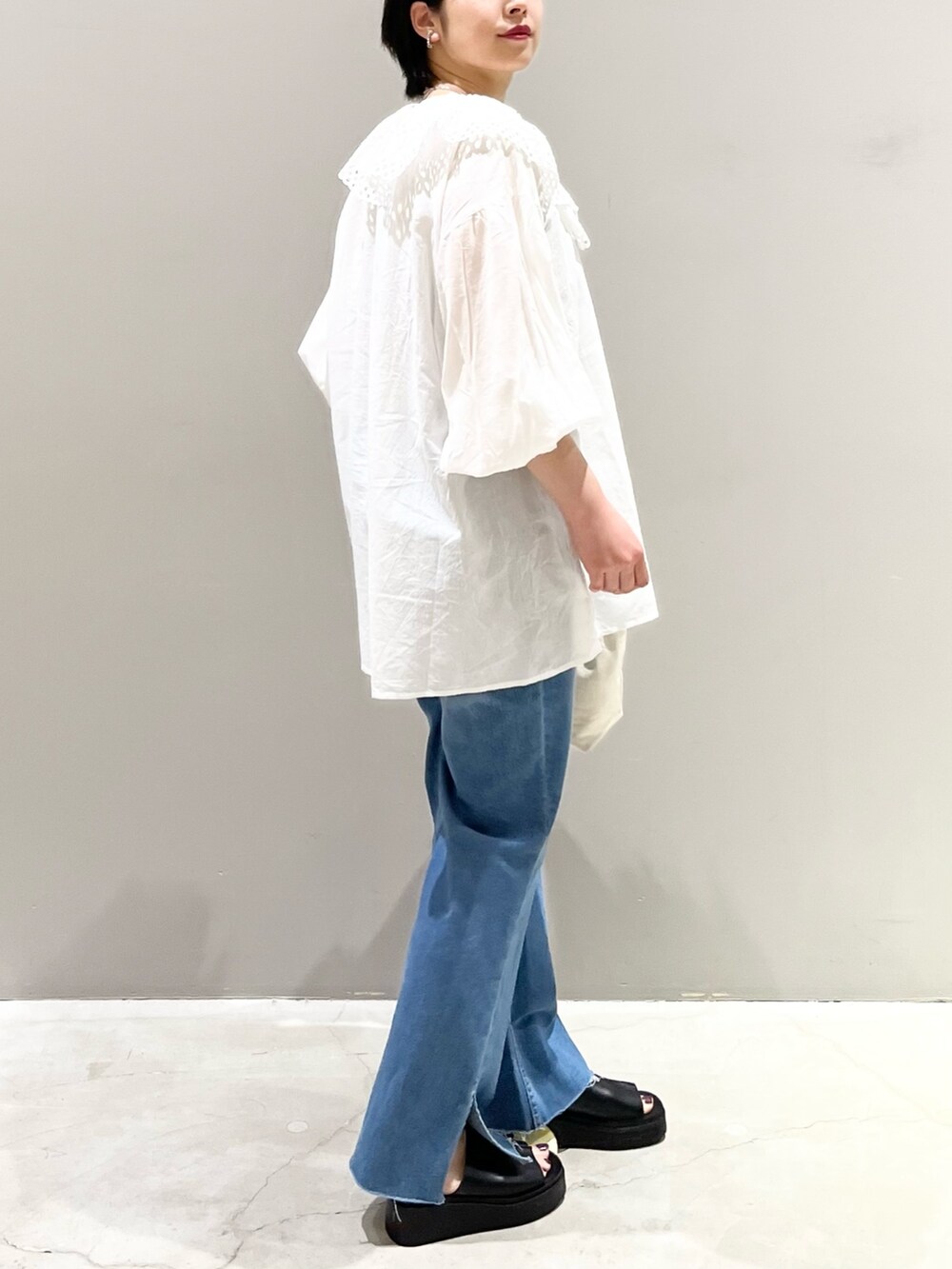 ホワイト系のシャツ/ブラウス、ブルー系のデニムパンツ、ブラック系のサンダルを着用したレディースの夏コーディネートの5枚目の写真