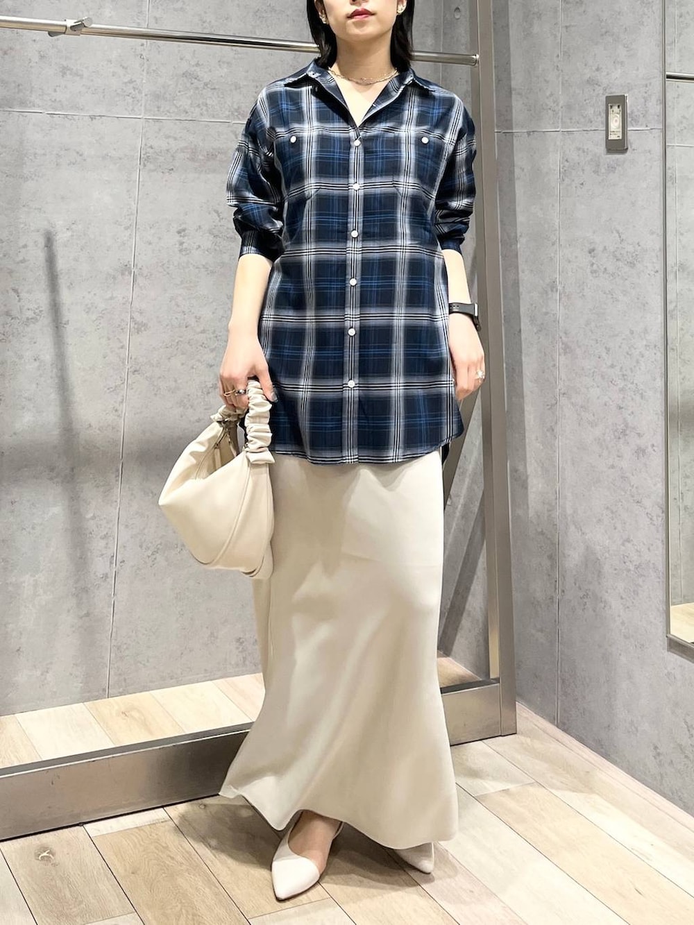 ホワイト系のショルダーバッグ、ホワイト系のスカート、ブルー系のシャツ/ブラウスを着用したレディースの冬コーディネートの6枚目の写真