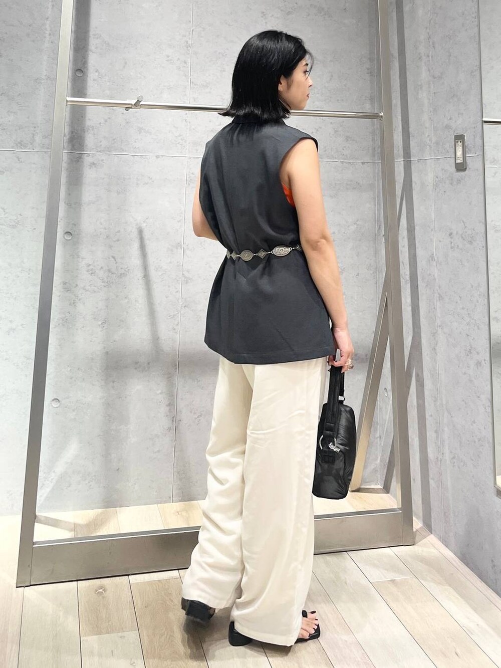 ホワイト系のその他パンツ、オレンジ系のタンクトップ、ブラック系のハンドバッグを着用したレディースの夏コーディネートの2枚目の写真