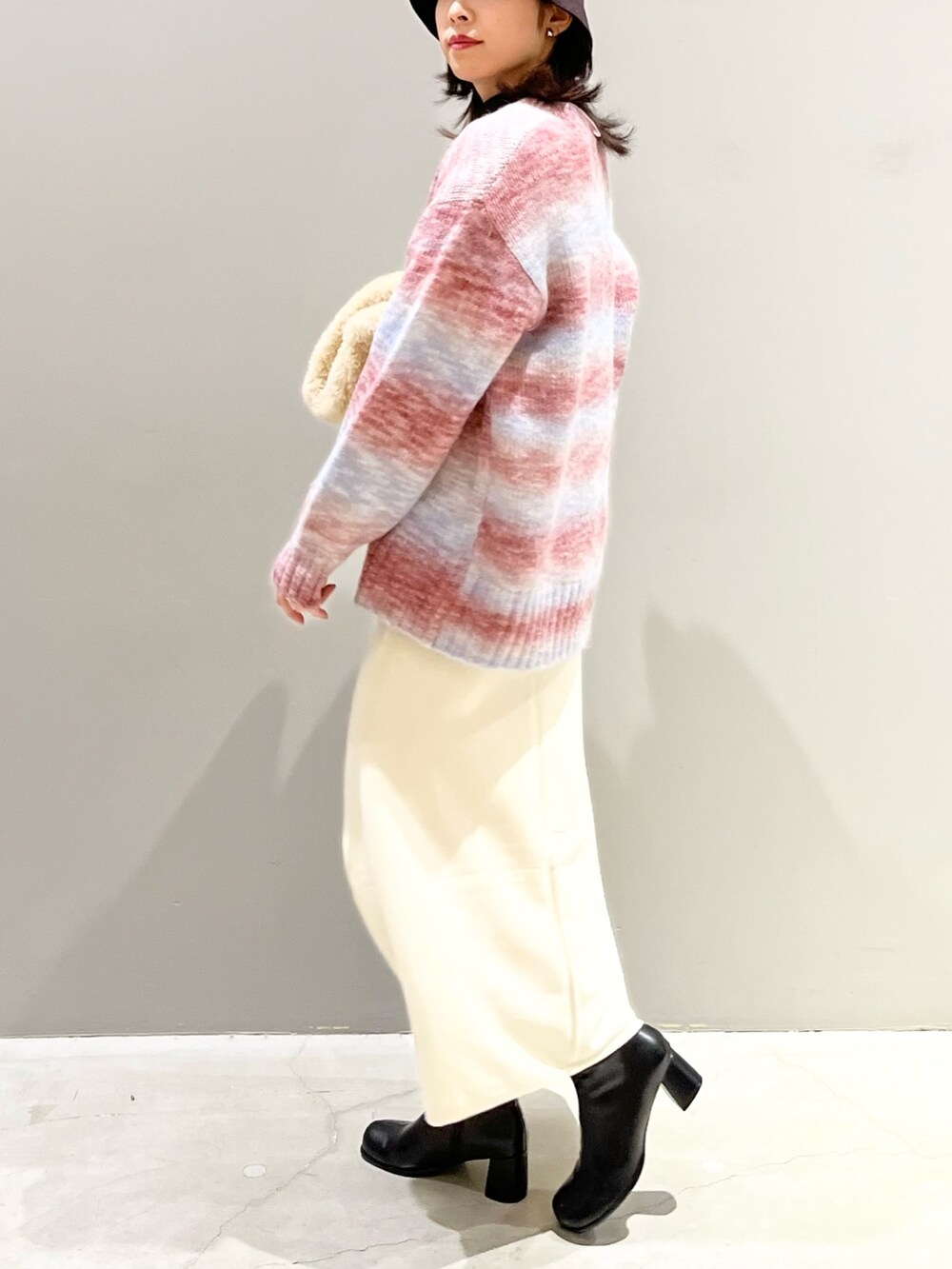 ブラック系のスカート、ブラック系のブーツ、パープル系のカーディガン/ボレロを着用したレディースの冬コーディネートの3枚目の写真