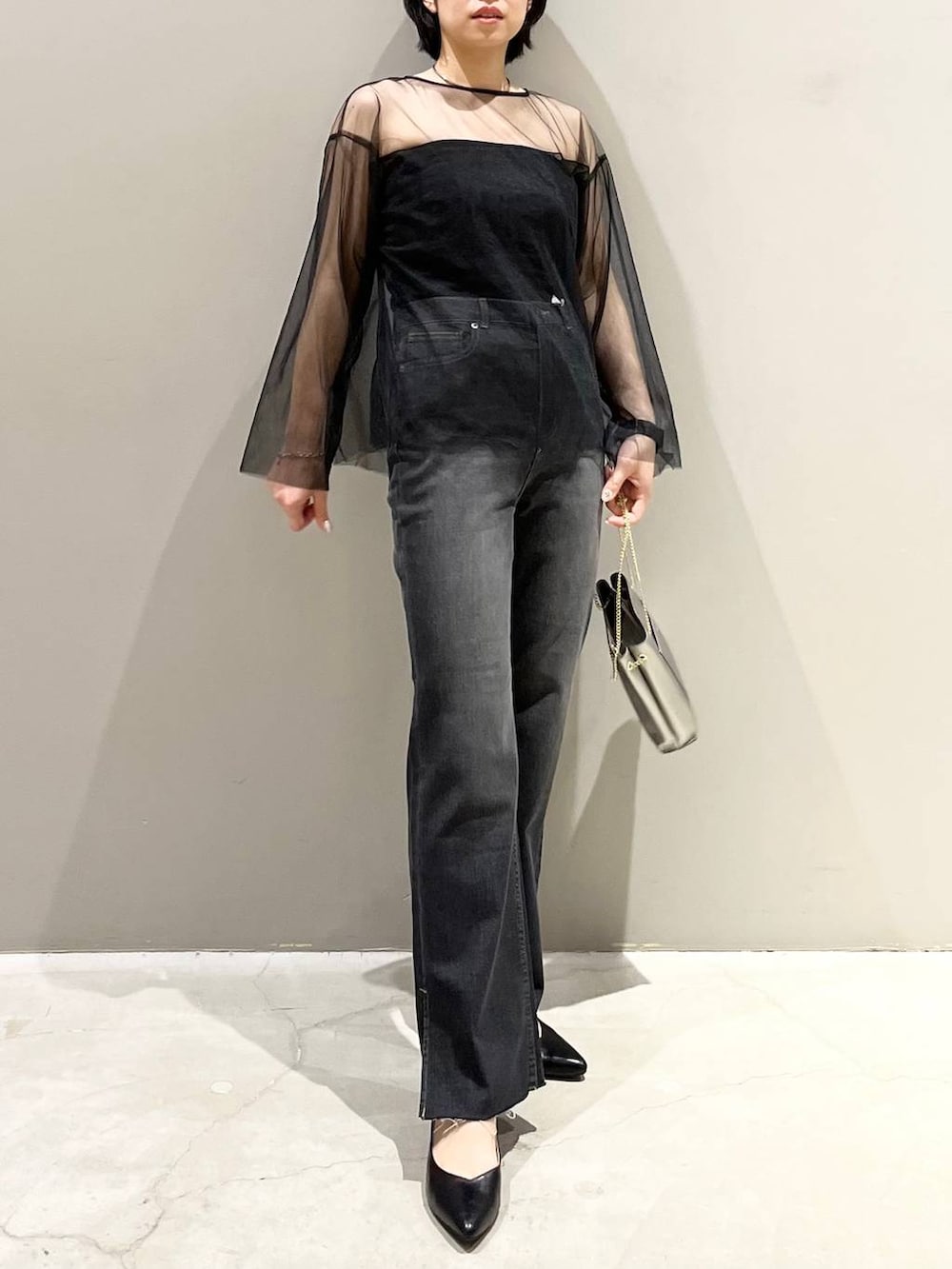 ブラック系のチューブトップ、ブラック系のTシャツ/カットソー、ブラック系のデニムパンツを着用したレディースの秋コーディネートの2枚目の写真