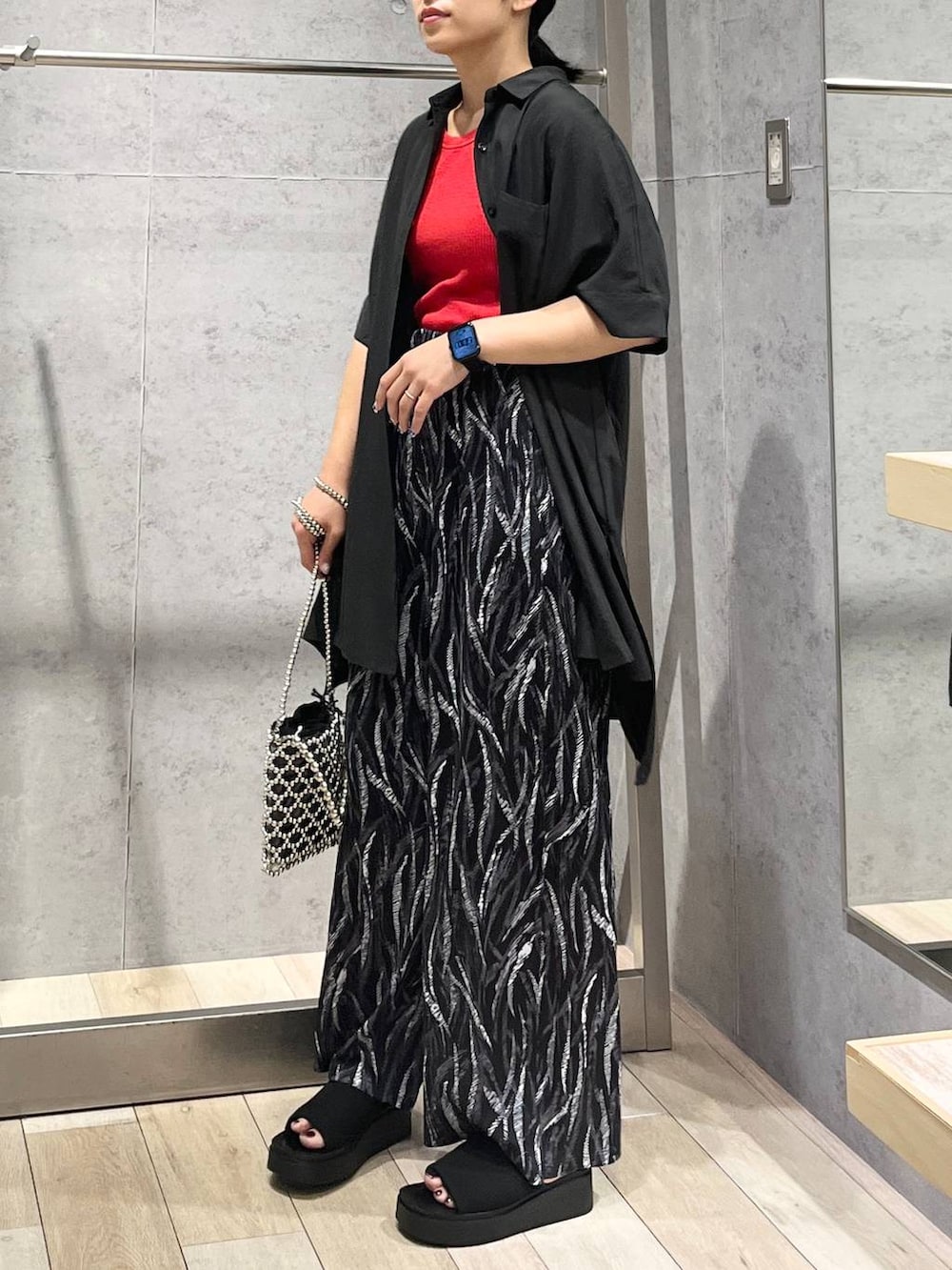 レッド系のTシャツ/カットソー、グレー系のシャツ/ブラウス、ブラック系のその他パンツを着用したレディースの夏コーディネートの2枚目の写真