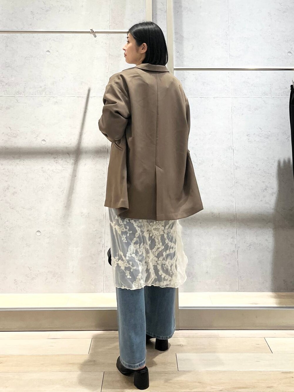 ブルー系のデニムパンツ、ブラック系のその他シューズ、ブラック系のショルダーバッグを着用したレディースの秋コーディネートの3枚目の写真