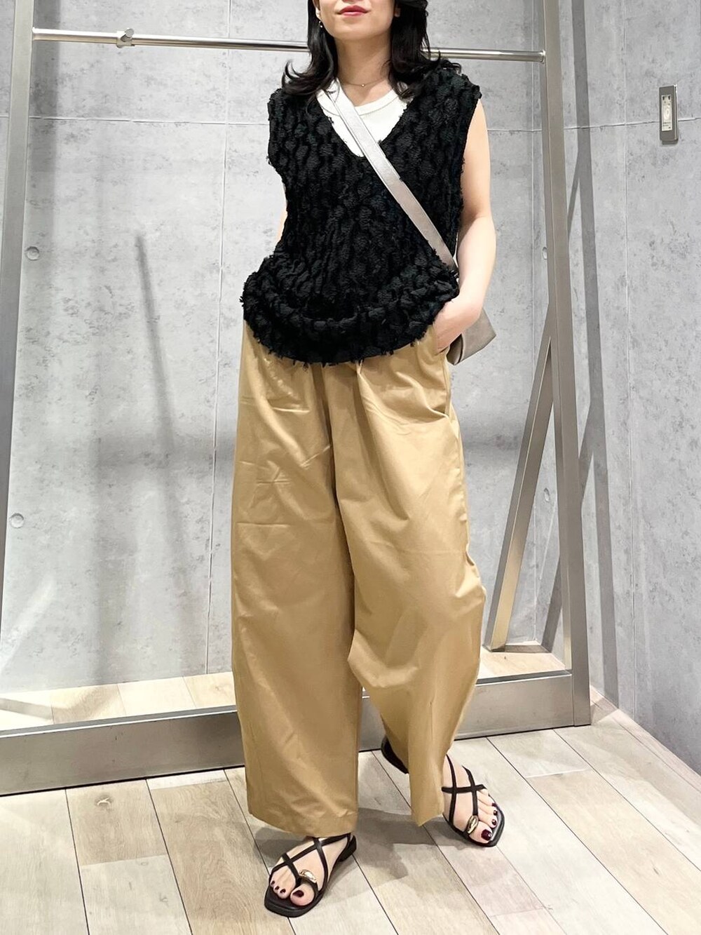 グレー系のショルダーバッグ、ホワイト系のTシャツ/カットソー、ベージュ系のその他パンツを着用したレディースの春コーディネートの3枚目の写真