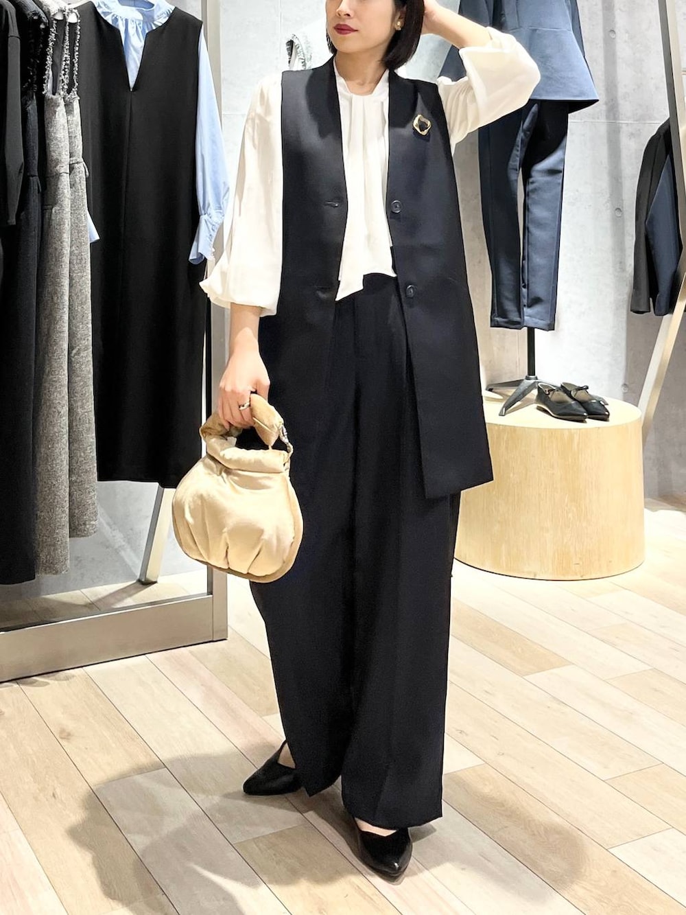 ベージュ系のハンドバッグ、ホワイト系のシャツ/ブラウス、ブラック系のパンプスを着用したレディースの冬コーディネートの3枚目の写真