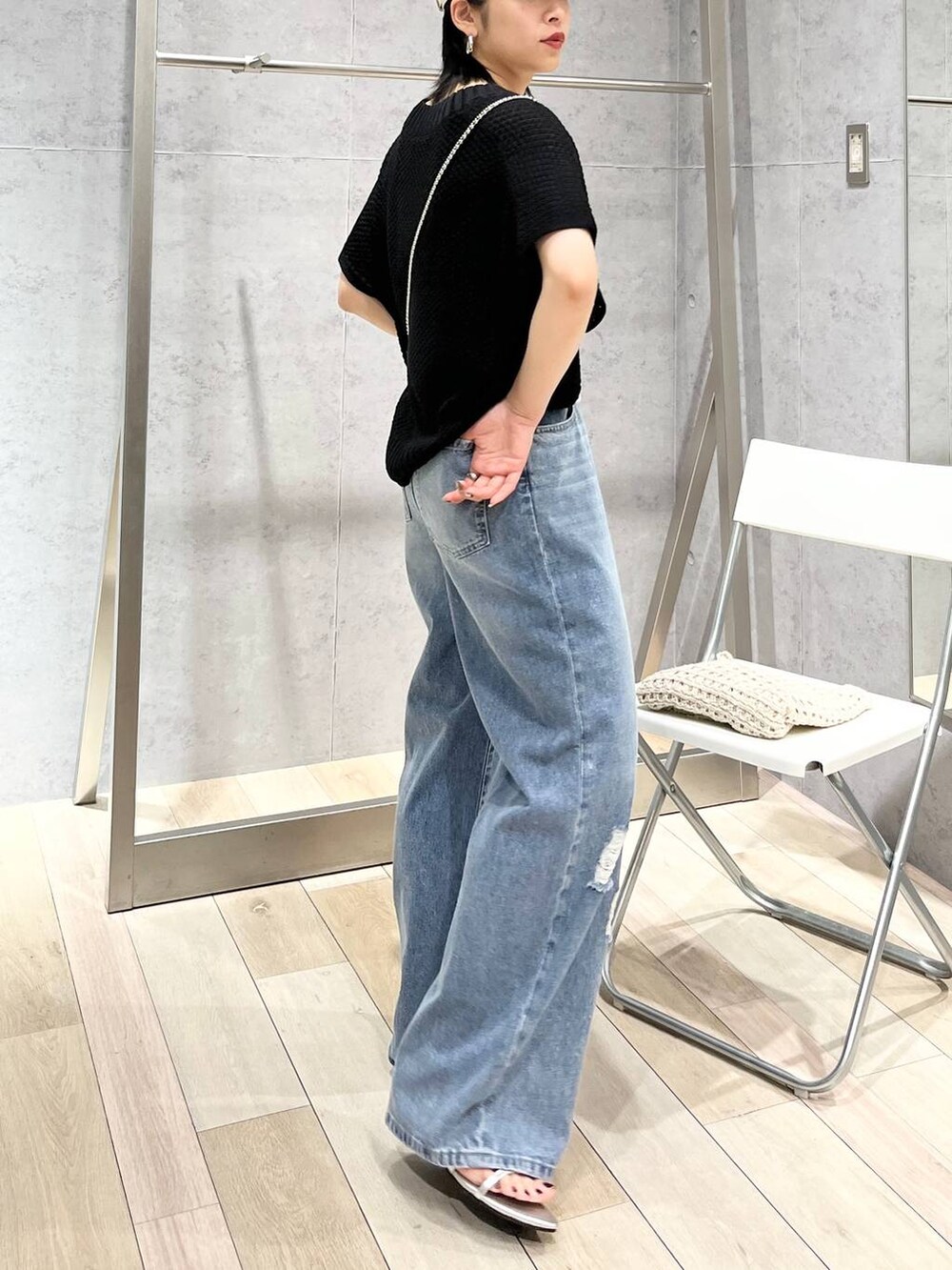 シルバー系のサンダル、ブラック系のニット/セーター、ブルー系のデニムパンツを着用したレディースの春コーディネートの6枚目の写真