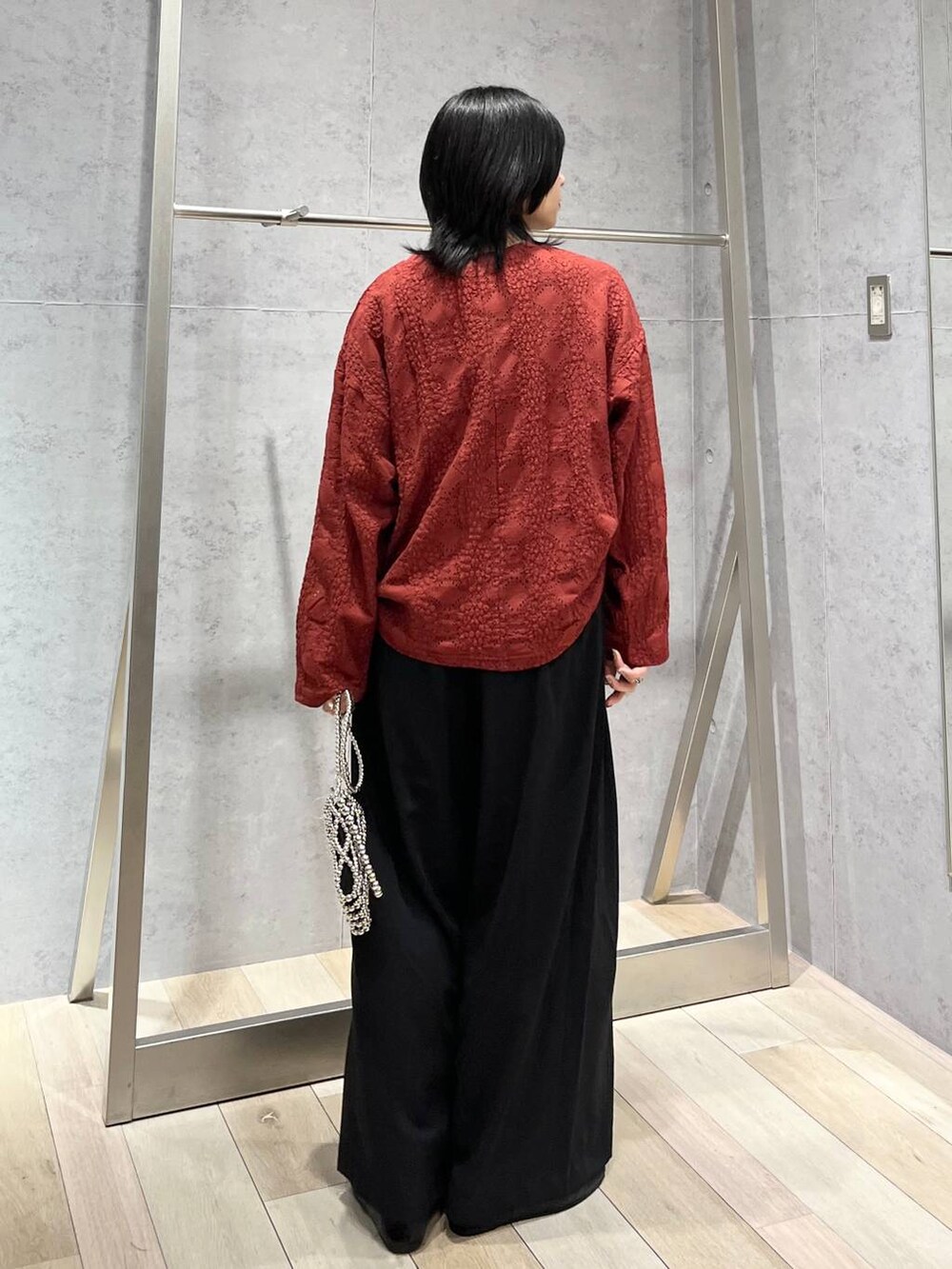 レッド系のTシャツ/カットソー、ブラック系のスラックス、シルバー系のショルダーバッグを着用したレディースの夏コーディネートの5枚目の写真