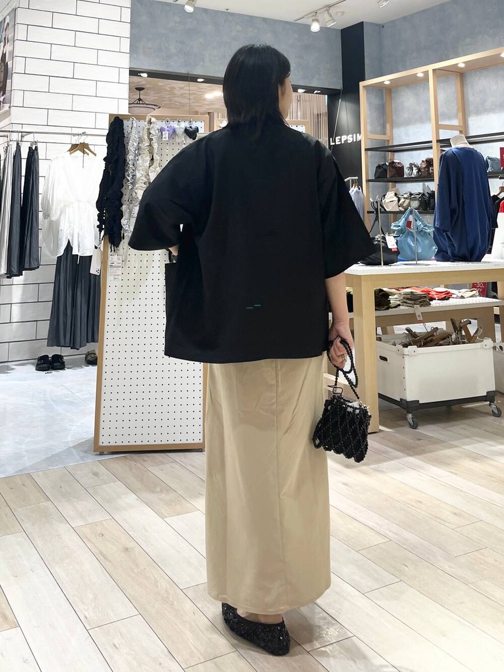 ブラック系のテーラードジャケット、ブラック系のショルダーバッグ、ホワイト系のTシャツ/カットソーを着用したレディースの夏コーディネートの4枚目の写真