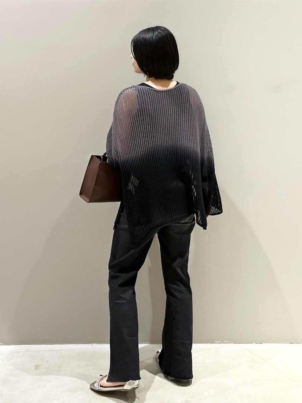 ブラック系のデニムパンツ、ブラウン系のバッグ、シルバー系のサンダルを着用したレディースの夏コーディネートの7枚目の写真