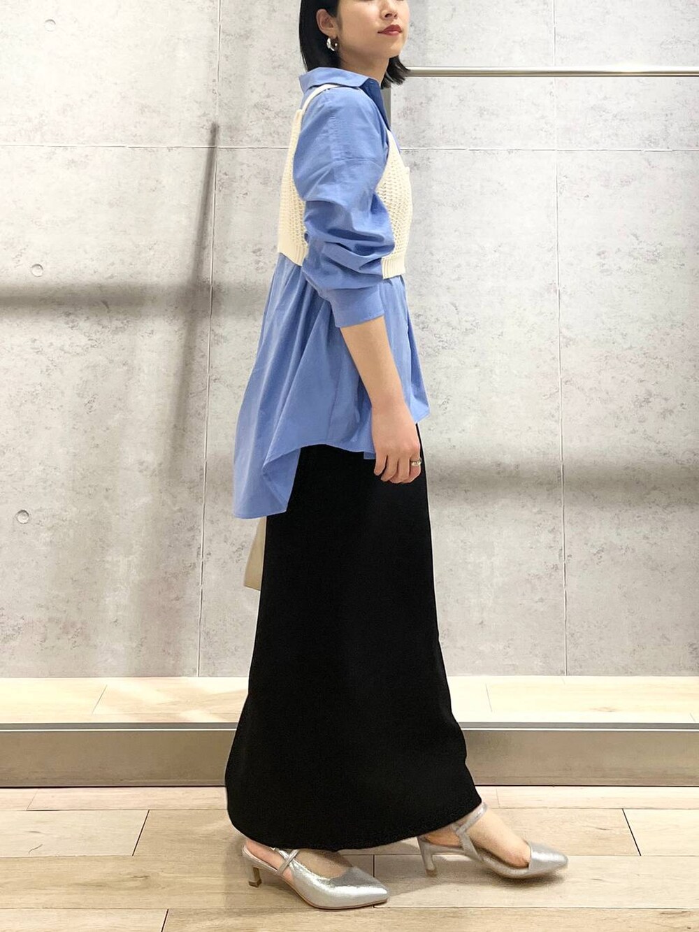 ブルー系のシャツ/ブラウス、ブラック系のスカート、ホワイト系のショルダーバッグを着用したレディースの冬コーディネートの5枚目の写真