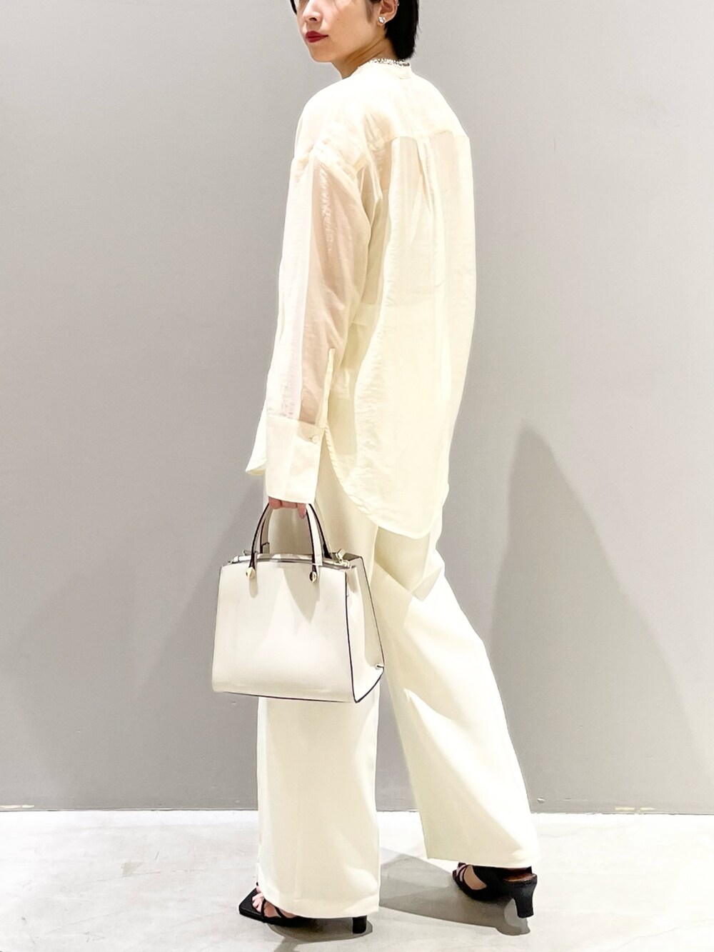 ホワイト系のシャツ/ブラウス、ホワイト系のスラックス、ホワイト系のショルダーバッグを着用したレディースの夏コーディネートの4枚目の写真