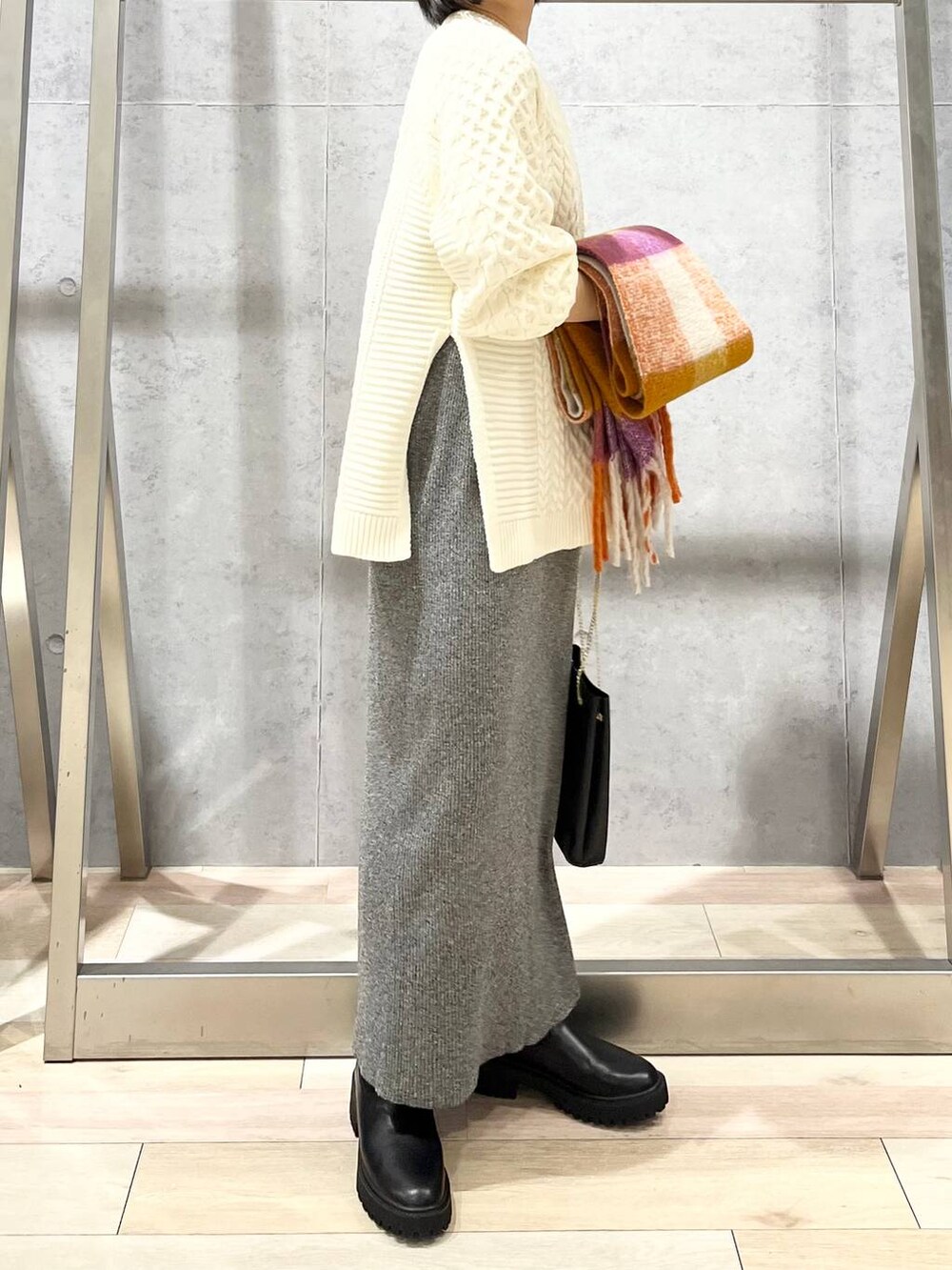 ブラック系のショルダーバッグ、ブラック系のブーツ、ホワイト系のその他トップスを着用したレディースの秋コーディネートの6枚目の写真