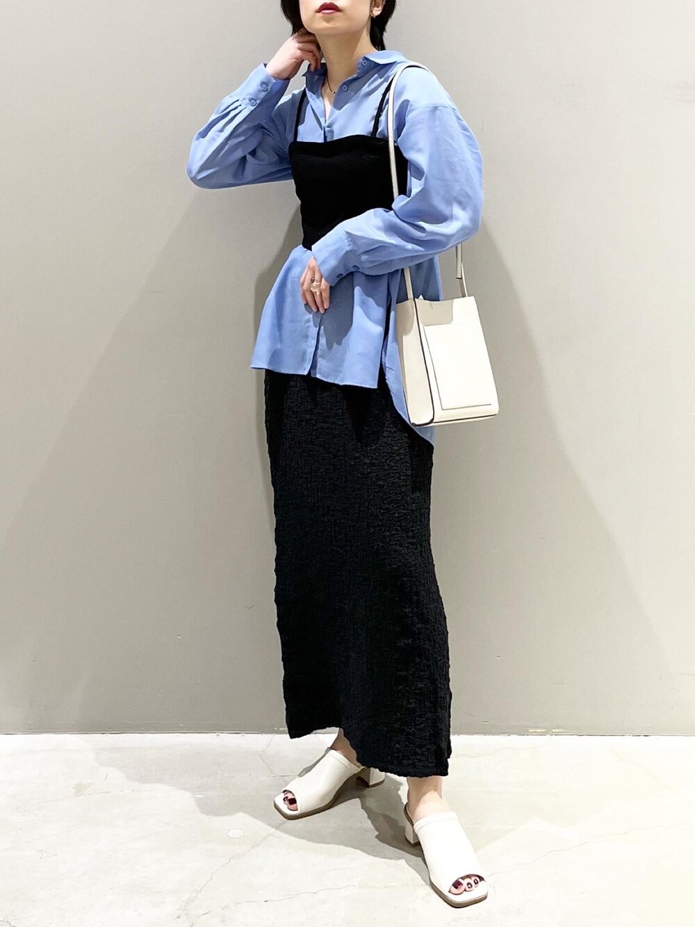 ホワイト系のサンダル、ブラック系のスカート、ブルー系のシャツ/ブラウスを着用したレディースの春コーディネートの3枚目の写真