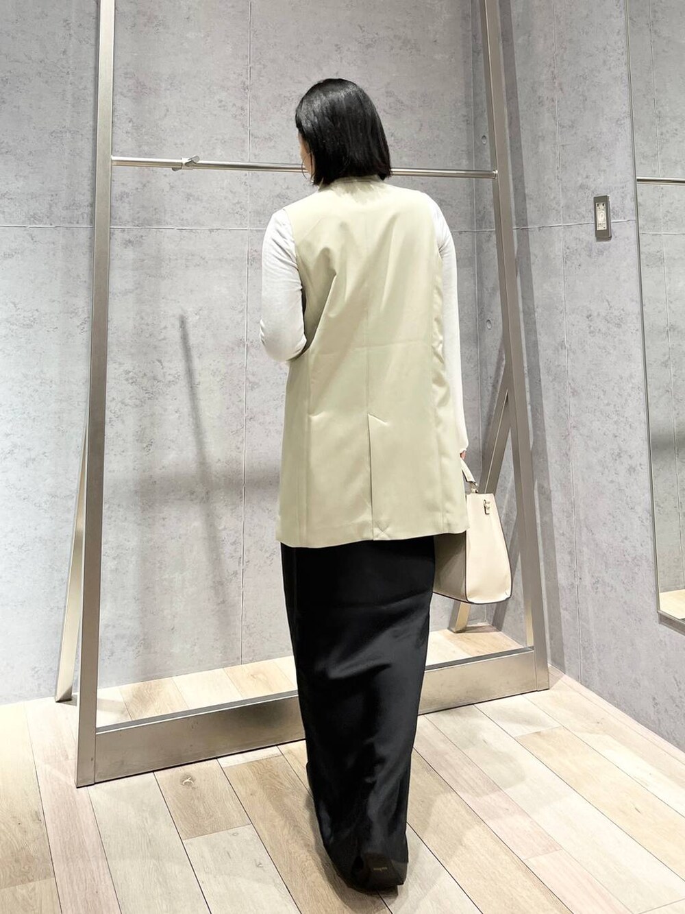 ホワイト系のTシャツ/カットソー、ブラック系のスカート、ホワイト系のショルダーバッグを着用したレディースの冬コーディネートの4枚目の写真