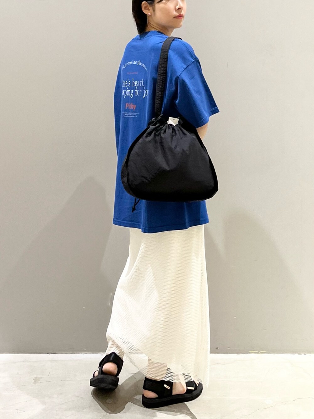 ホワイト系のスカート、ブラック系のサンダル、ブラック系のショルダーバッグを着用したレディースの夏コーディネートの4枚目の写真