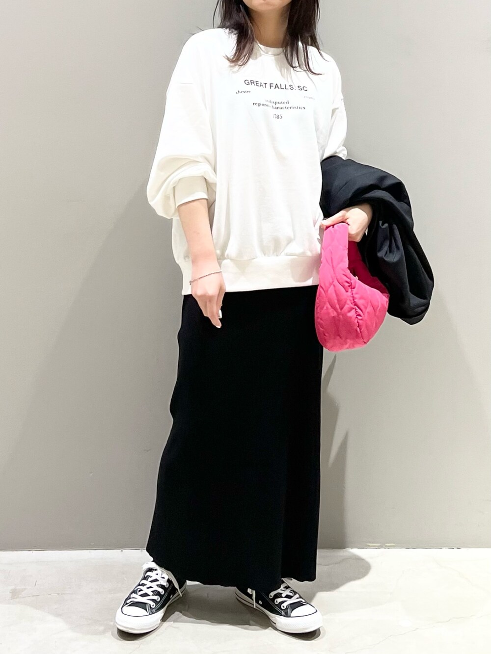 ブラック系のスニーカー、ブラック系のスカート、ピンク系のショルダーバッグを着用したレディースの秋コーディネートの5枚目の写真