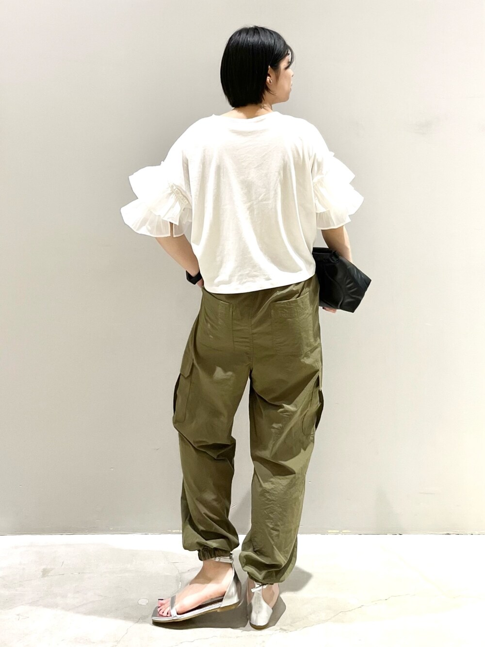 シルバー系のサンダル、ブラック系のバッグ、ホワイト系のTシャツ/カットソーを着用したレディースの秋コーディネートの4枚目の写真