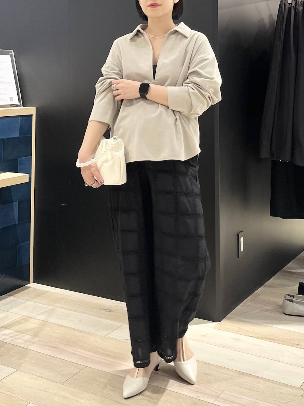 ホワイト系のパンプス、ホワイト系のショルダーバッグ、ベージュ系のシャツ/ブラウスを着用したレディースの冬コーディネートの2枚目の写真