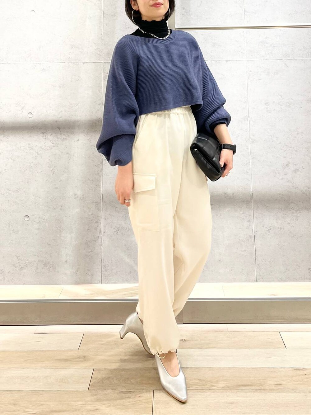 ブルー系のワンピース、ブラック系のTシャツ/カットソー、ブラック系のショルダーバッグを着用したレディースの秋コーディネートの2枚目の写真