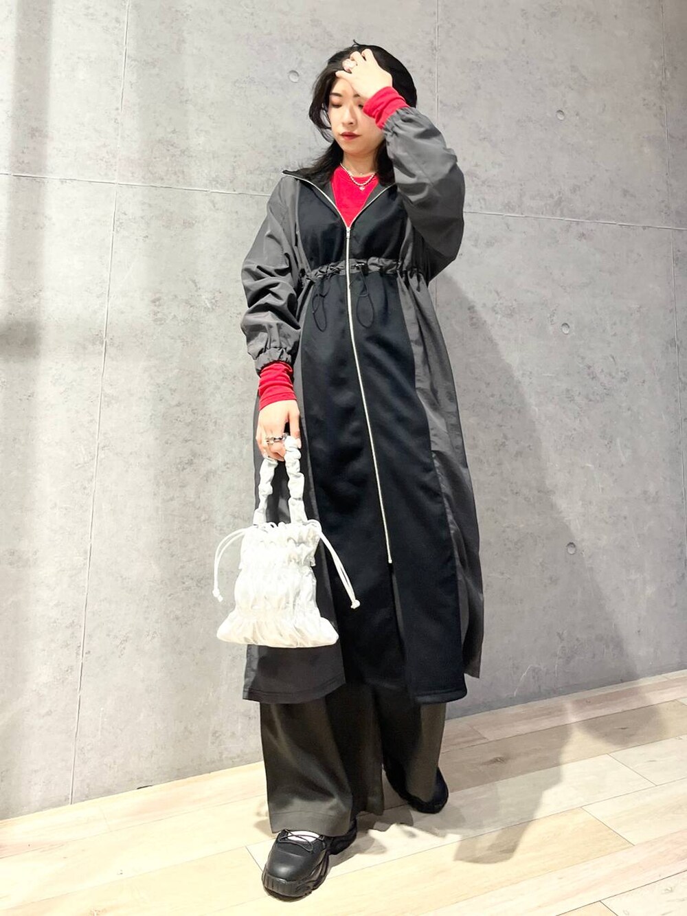 シルバー系のショルダーバッグ、グレー系のその他パンツ、レッド系のTシャツ/カットソーを着用したレディースの冬コーディネートの2枚目の写真