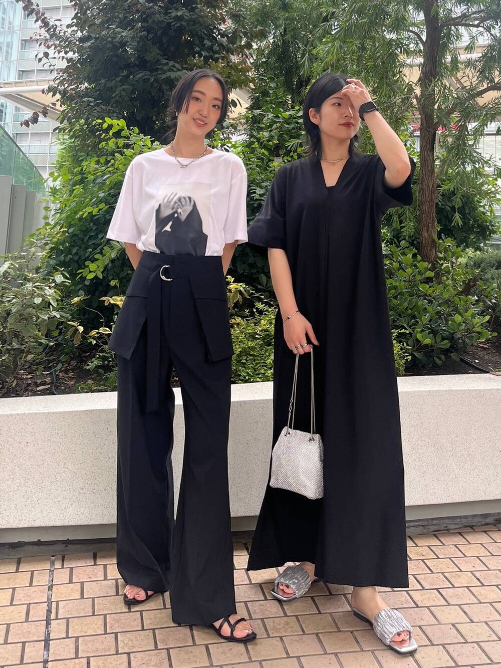 シルバー系のショルダーバッグ、ブラック系のサンダル、ブラック系のワンピースを着用したレディースの夏コーディネートの2枚目の写真