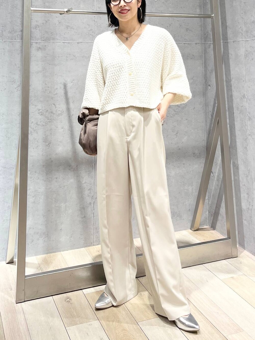 ブラウン系のハンドバッグ、グレー系のパンプス、ホワイト系のカーディガン/ボレロを着用したレディースの冬コーディネートの3枚目の写真