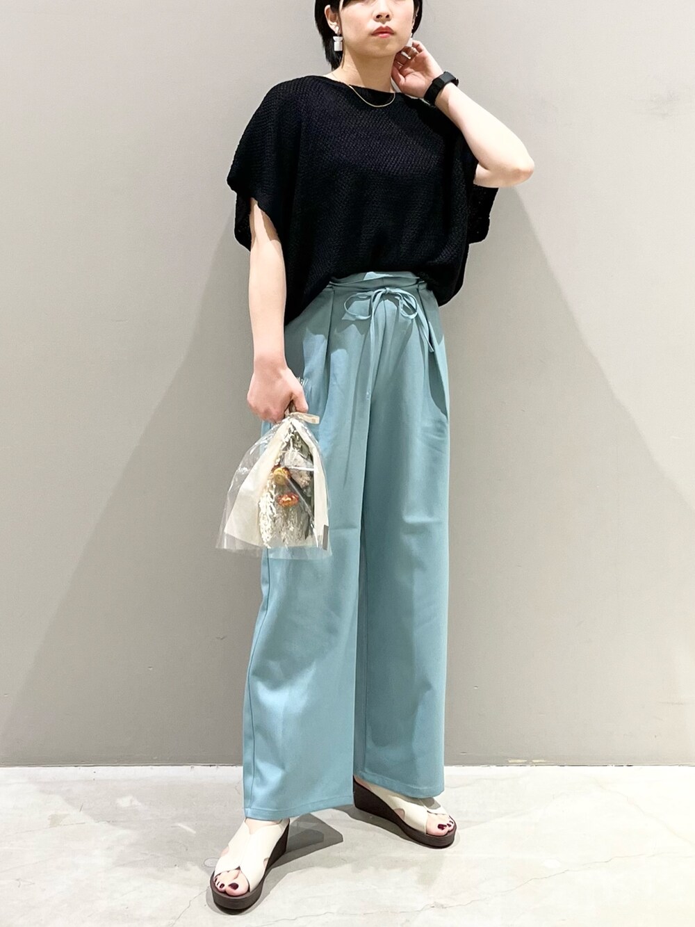 ブラック系のその他トップス、グリーン系のスラックス、ホワイト系のサンダルを着用したレディースの春コーディネートの4枚目の写真