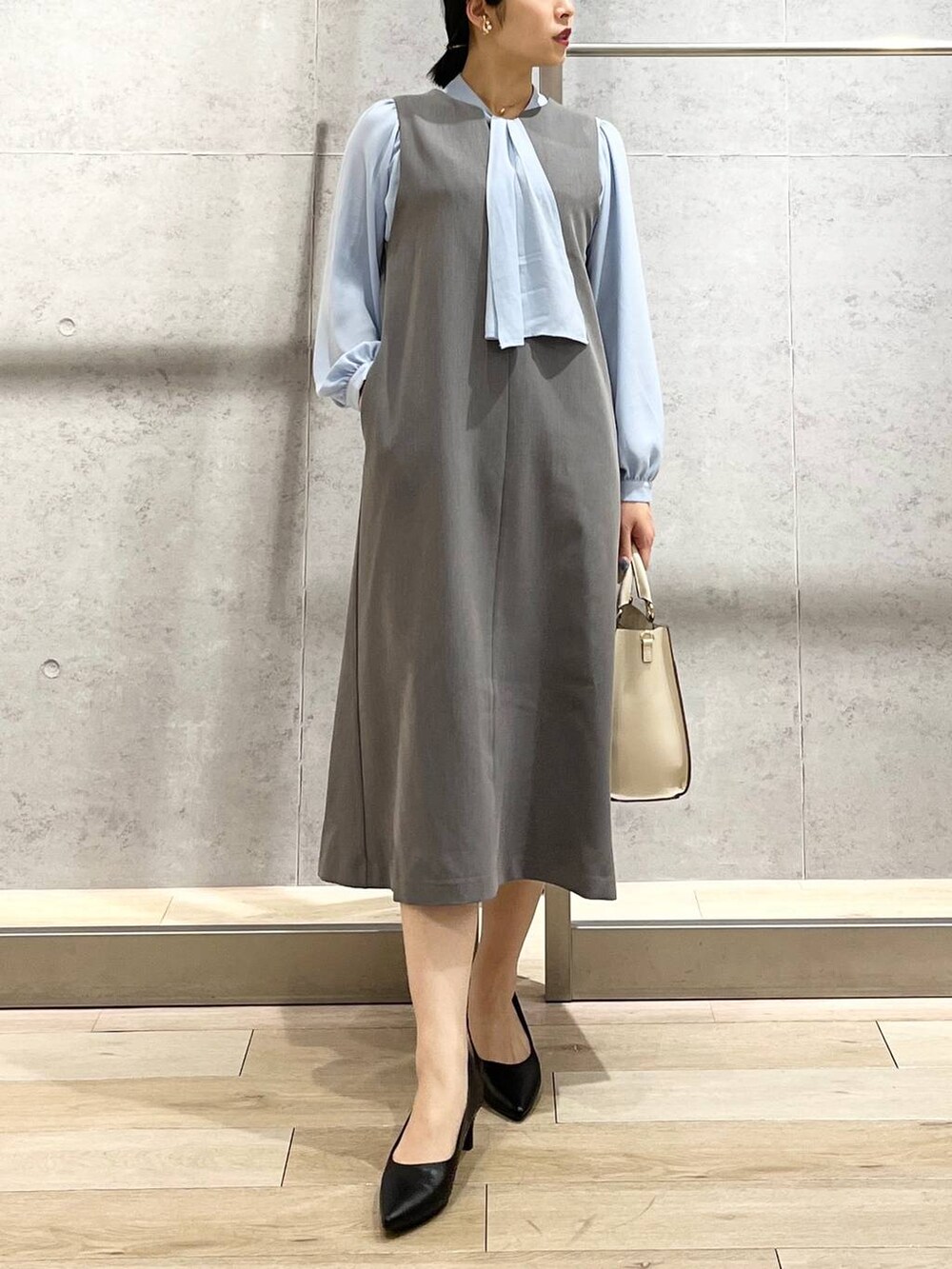 ブルー系のシャツ/ブラウス、ホワイト系のショルダーバッグ、ブラック系のパンプスを着用したレディースの冬コーディネートの2枚目の写真