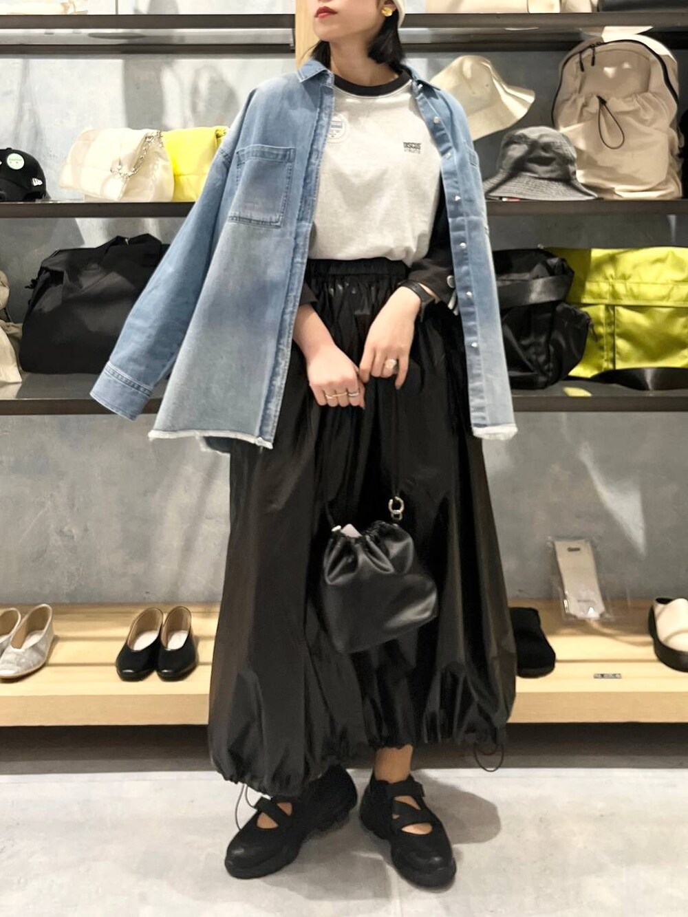 ブラック系のショルダーバッグ、ブラック系のTシャツ/カットソー、ブラック系のスニーカーを着用したレディースの春コーディネートの9枚目の写真