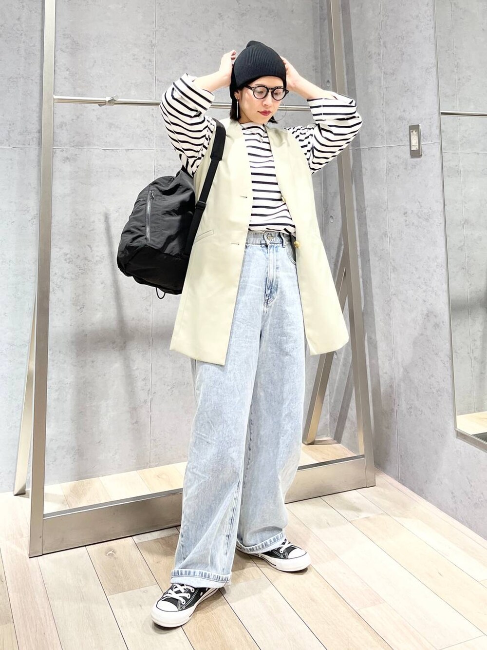 ブラック系のバックパック/リュック、ブルー系のTシャツ/カットソー、ブルー系のデニムパンツを着用したレディースの冬コーディネートの8枚目の写真