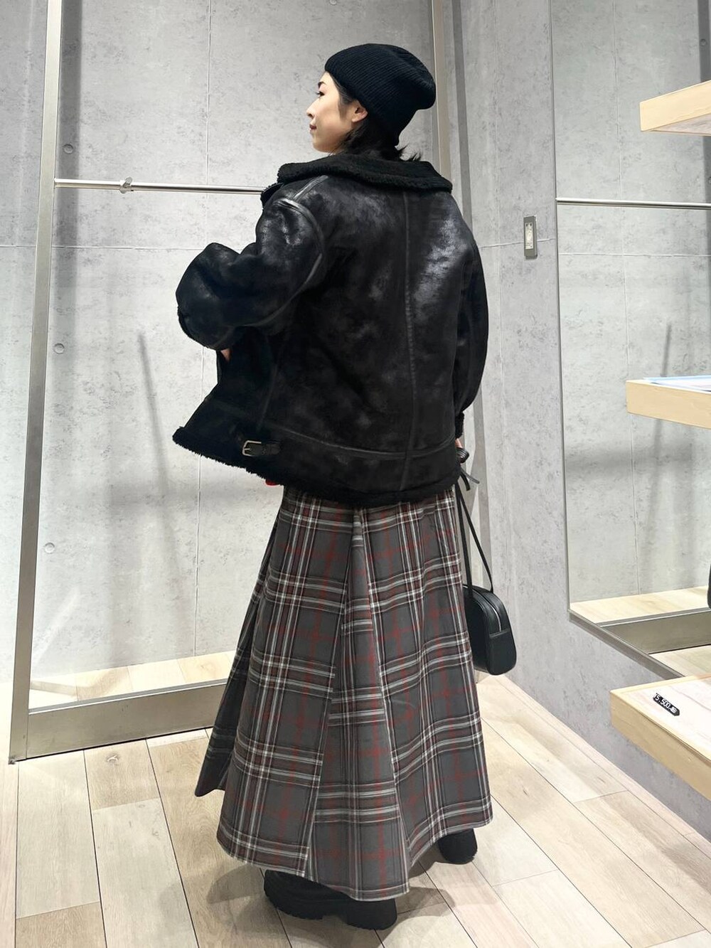 ブラック系のブーツ、ブラック系のその他アウター、グレー系のスカートを着用したレディースの冬コーディネートの7枚目の写真