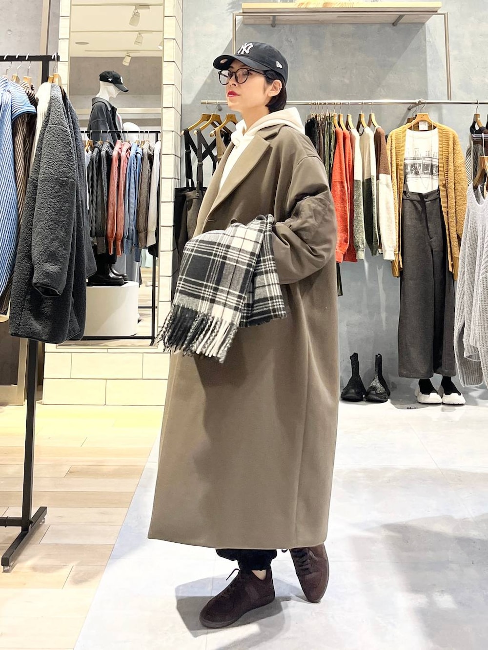 ブラウン系のスニーカー、ホワイト系のパーカー、ブラウン系のその他アウターを着用したレディースの秋コーディネートの2枚目の写真