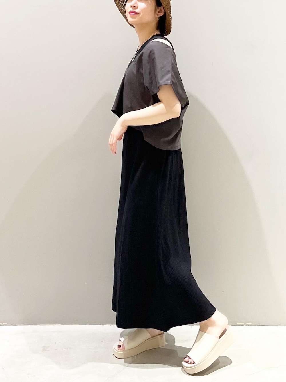 ベージュ系のサンダル、ブラック系のワンピース、ブラウン系のハットを着用したレディースの春コーディネートの2枚目の写真