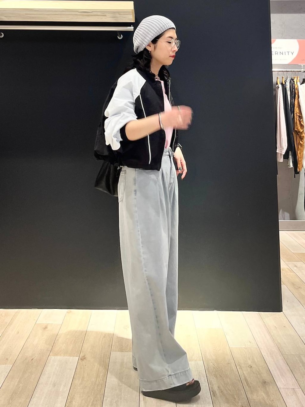 ピンク系のTシャツ/カットソー、ブラック系のトートバッグ、ブラック系のサンダルを着用したレディースの春コーディネートの3枚目の写真