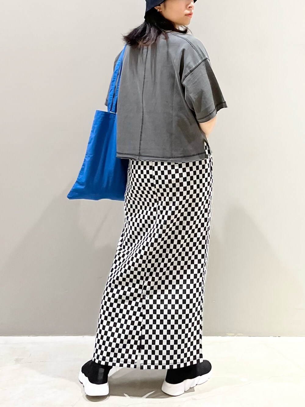 ブルー系のトートバッグ、ブラック系のシューズ、グレー系のTシャツ/カットソーを着用したレディースの秋コーディネートの4枚目の写真