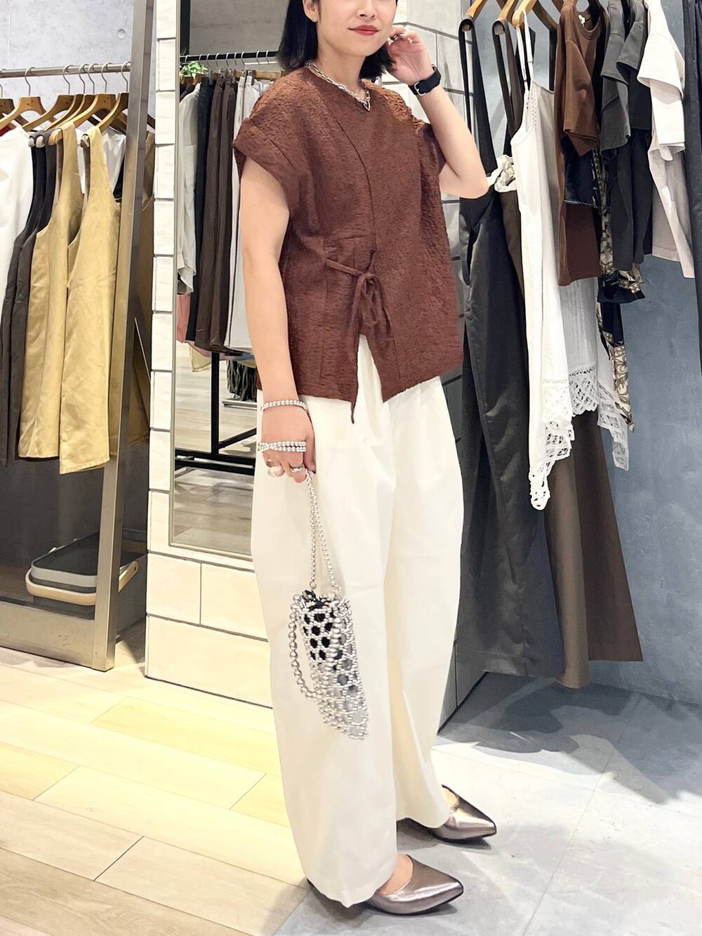 シルバー系のショルダーバッグ、ブラウン系のTシャツ/カットソー、ホワイト系のその他パンツを着用したレディースの夏コーディネートの3枚目の写真