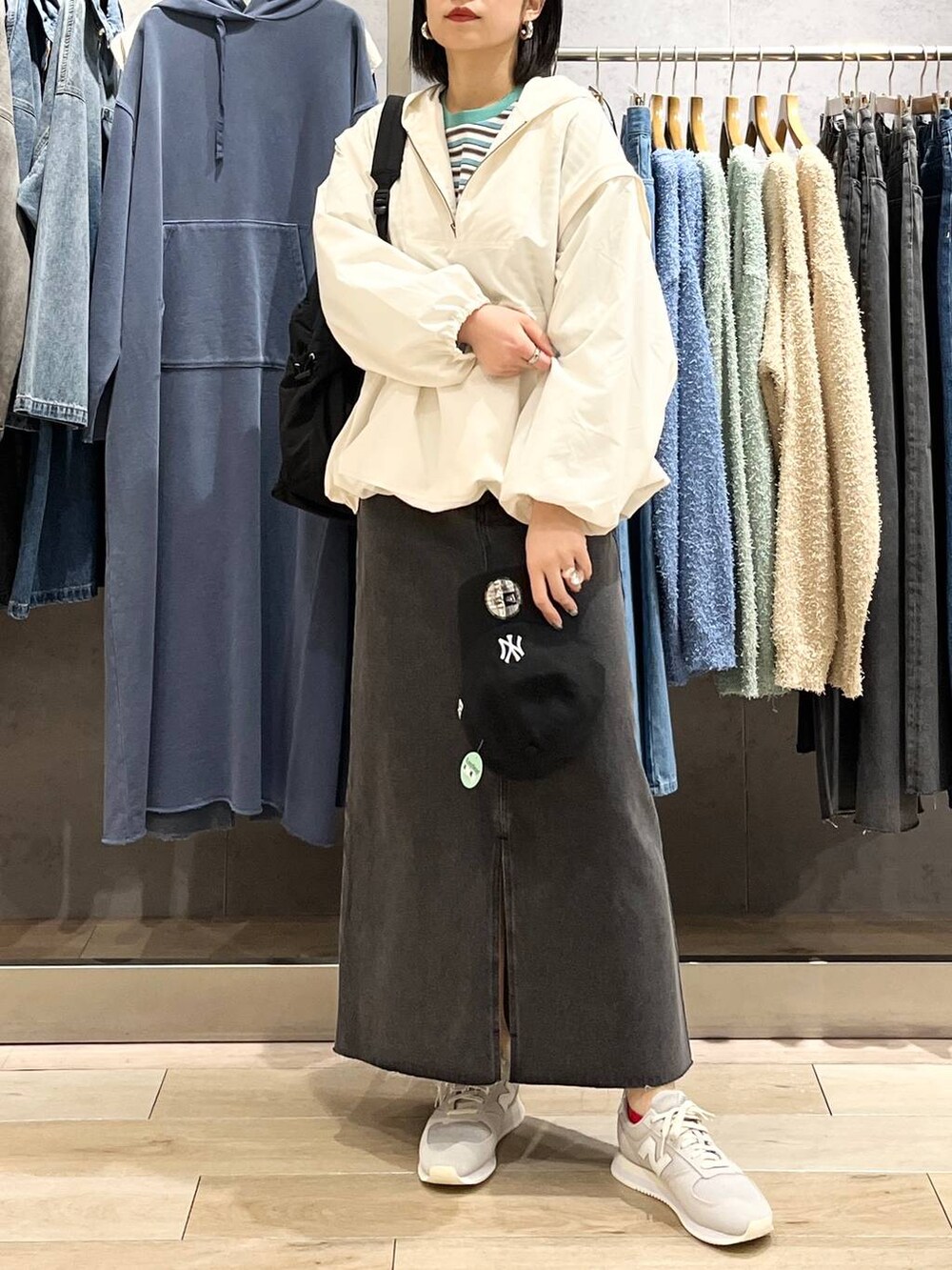 ブラック系のショルダーバッグ、ホワイト系のTシャツ/カットソー、ブラック系のスカートを着用したレディースの春コーディネートの2枚目の写真