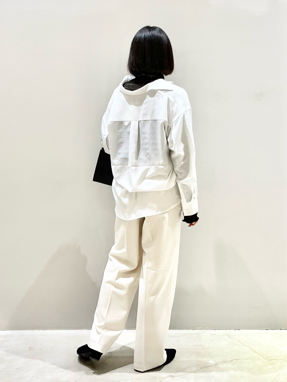 ブラック系のシューズ、ブラック系のパンツ、ブラック系のショルダーバッグを着用したレディースの春コーディネートの3枚目の写真