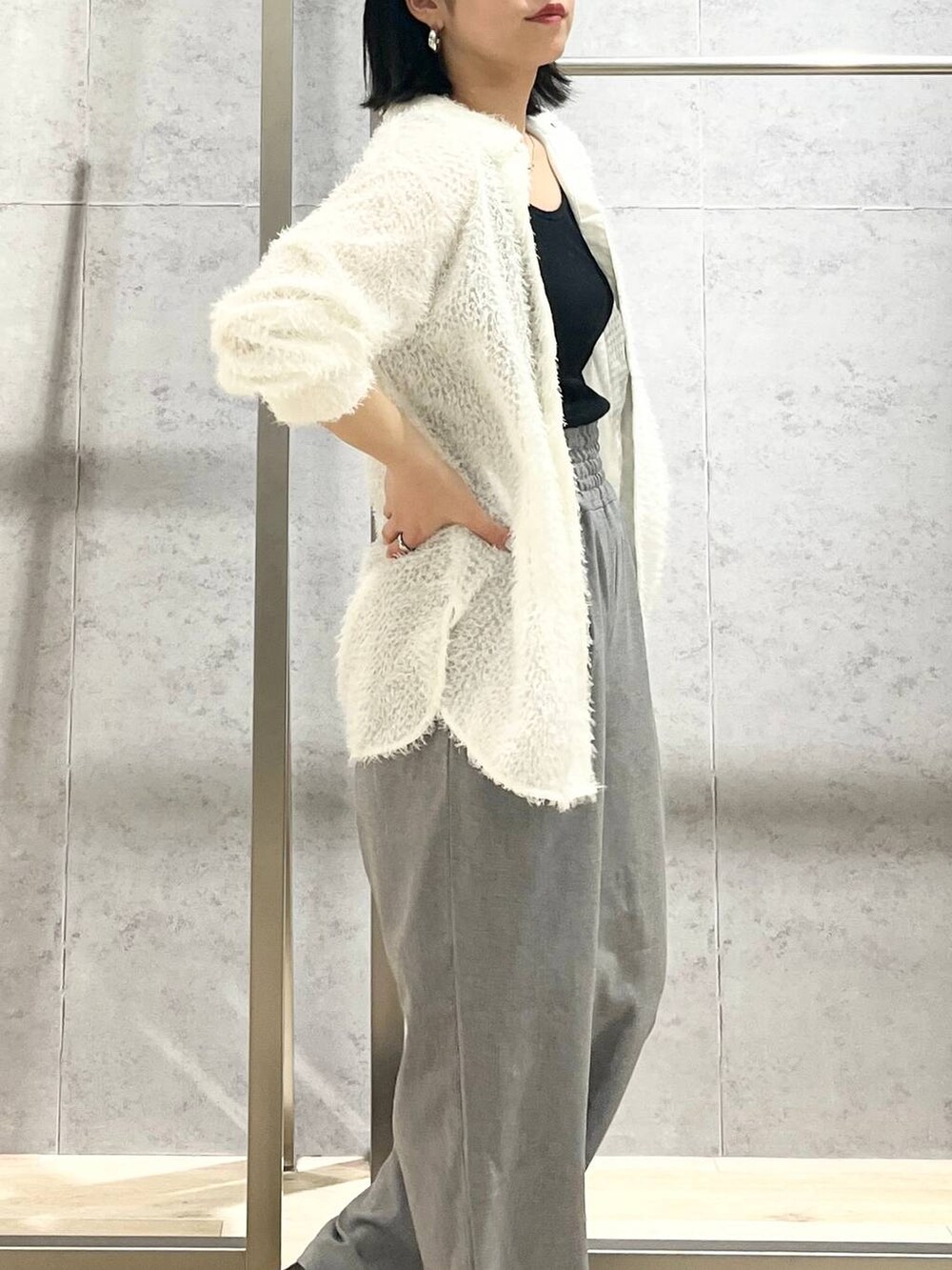 ブラック系のハンドバッグ、ホワイト系のシャツ/ブラウス、ブラック系のパンプスを着用したレディースの春コーディネートの4枚目の写真