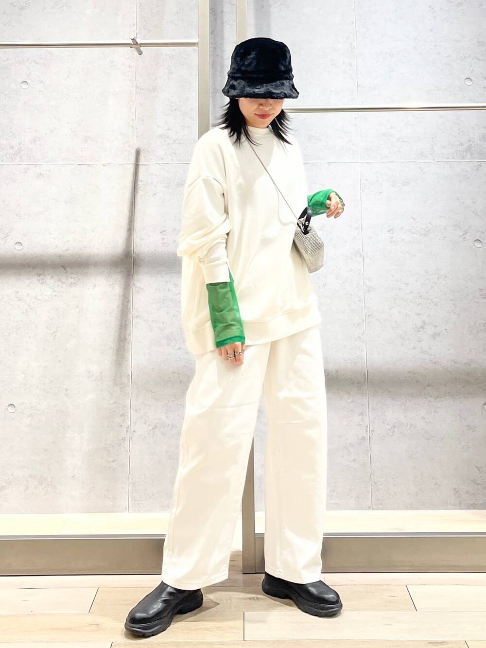 ブラック系のTシャツ/カットソー、ホワイト系のスウェット、ブラック系のブーツを着用したレディースの冬コーディネートの6枚目の写真