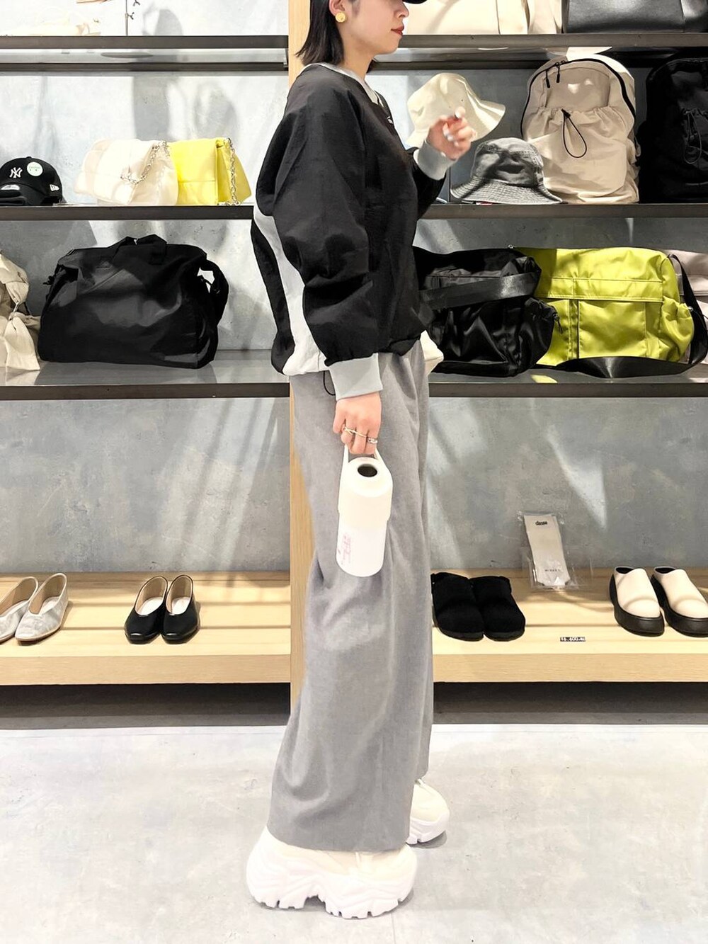 ホワイト系のスニーカー、ベージュ系のショルダーバッグ、グレー系のスラックスを着用したレディースの春コーディネートの7枚目の写真