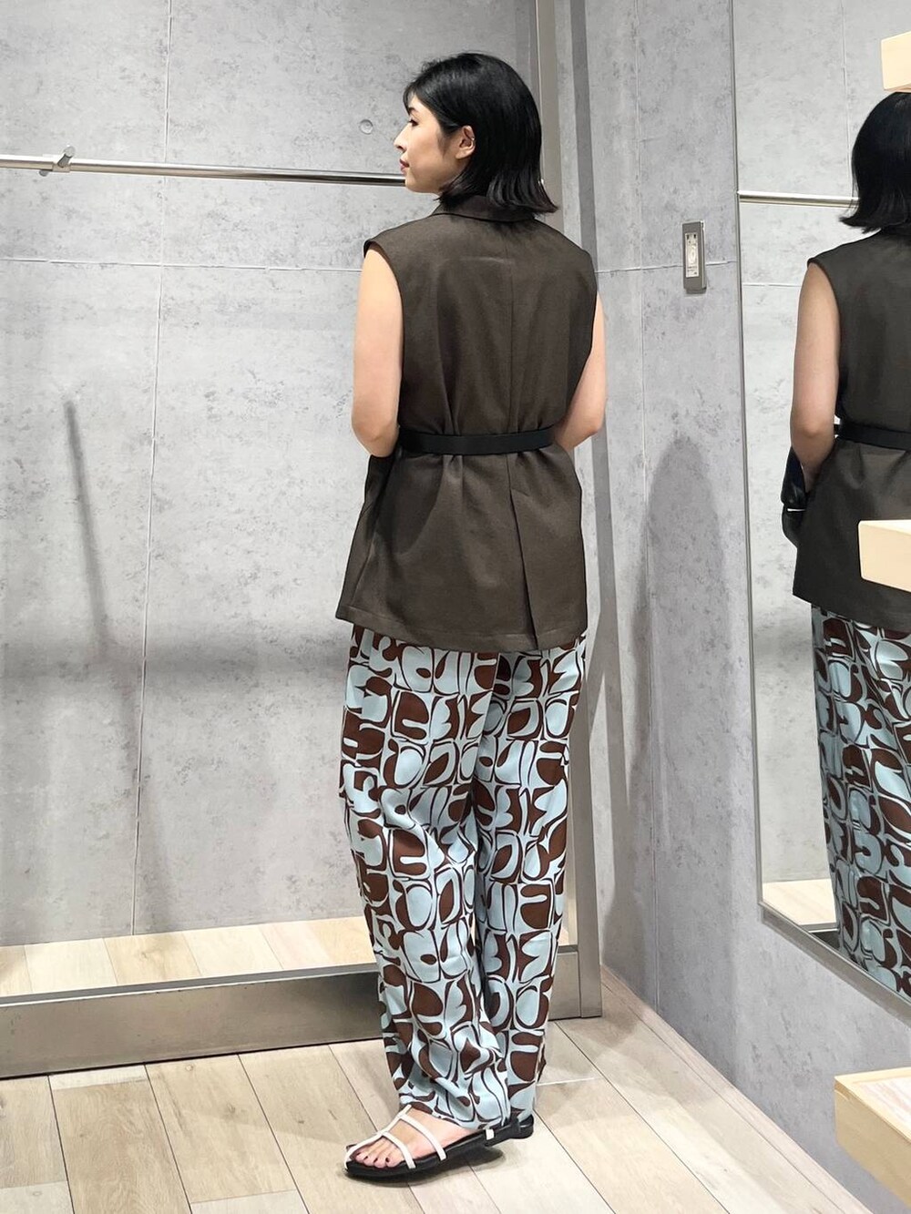 ホワイト系のタンクトップ、ホワイト系のサンダル、ブラック系のハンドバッグを着用したレディースの夏コーディネートの5枚目の写真