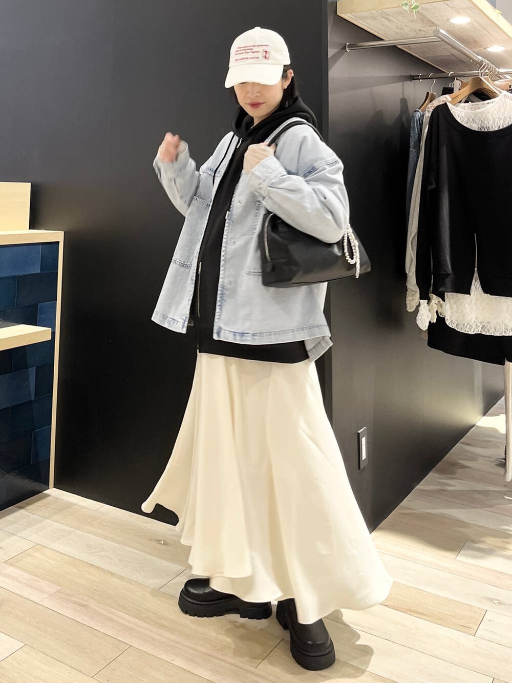 ブラック系のパーカー、ブルー系のシャツ/ブラウス、ブラック系のボストンバッグを着用したレディースの春コーディネートの5枚目の写真