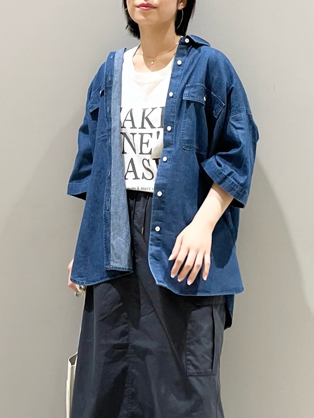 オレンジ系のバッグ、グレー系のスカート、ベージュ系のサンダルを着用したレディースの夏コーディネートの6枚目の写真