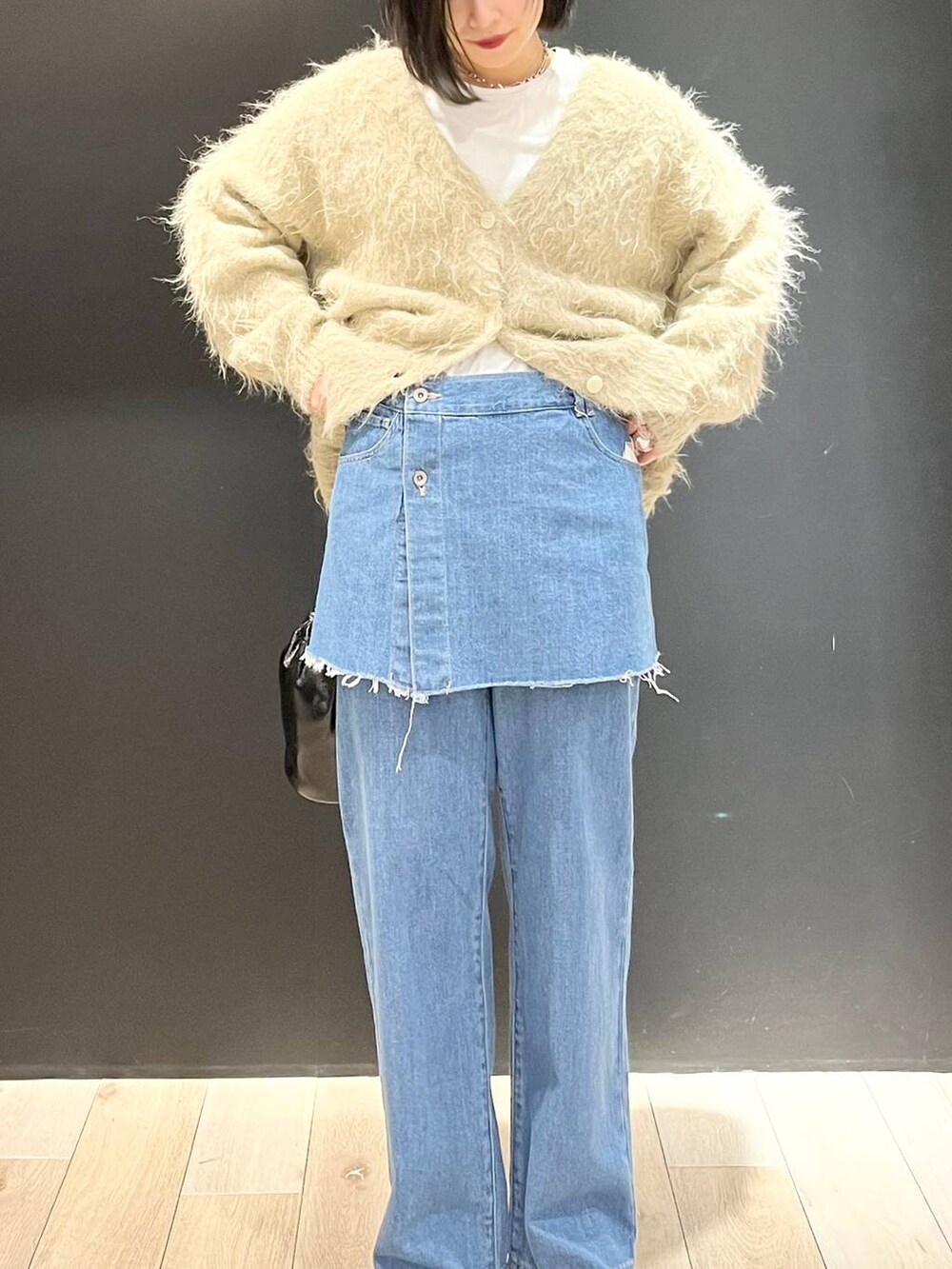 ホワイト系のTシャツ/カットソー、ブラック系のブーツ、ベージュ系のカーディガン/ボレロを着用したレディースの冬コーディネートの2枚目の写真