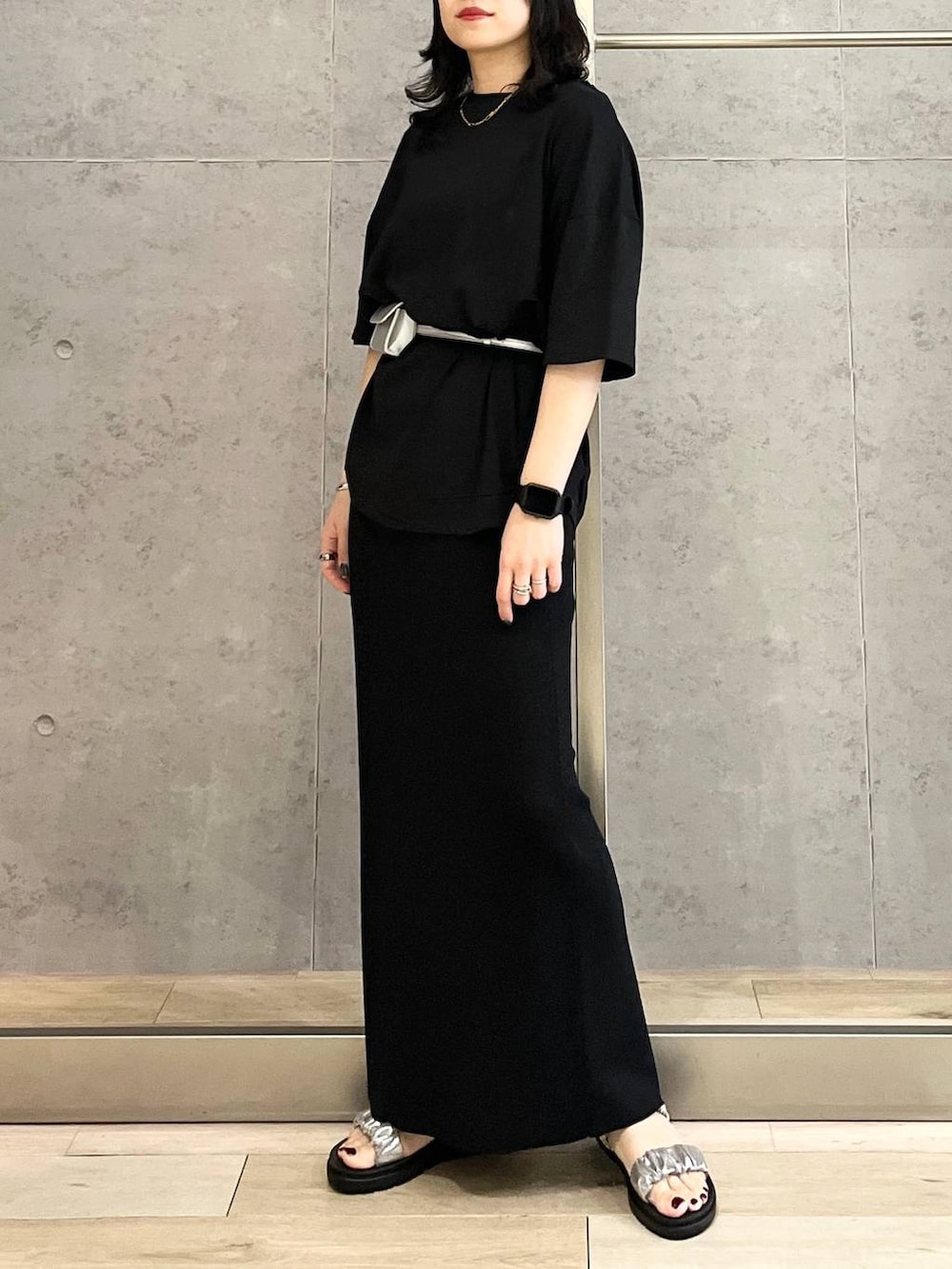 ブラック系のスカート、ブラック系のTシャツ/カットソー、シルバー系のサンダルを着用したレディースの春コーディネートの7枚目の写真